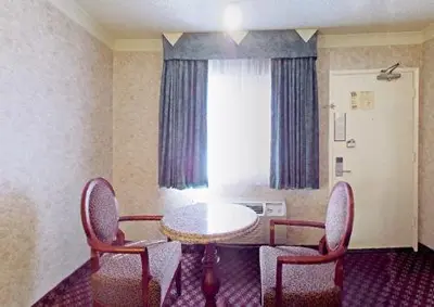 a room with a table and chairs and a window at Americas Best Value Inn & Suites - Fontana in Fontana