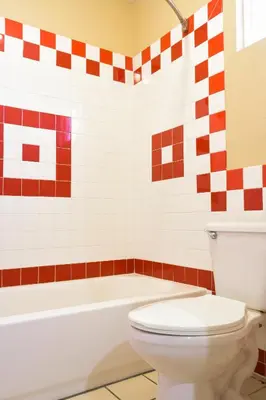 a bathroom with a white toilet and a bath tub at Covina Motel in West Covina