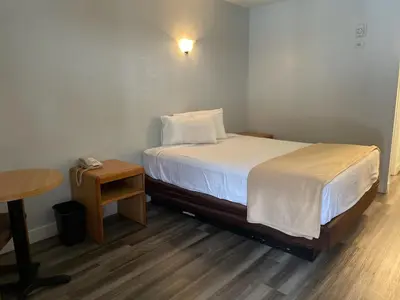 a small bedroom with a bed and a table at Premier Inns Thousand Oaks in Thousand Oaks