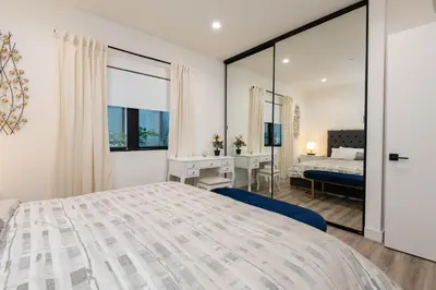 a bedroom with a large bed and a desk at Regency Modern Apartments in Glendale