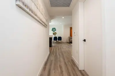 an empty hallway with white walls and wood floors at Regency Modern Apartments in Glendale