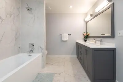 a bathroom with a tub and a sink and a mirror at Regency Modern Apartments in Glendale