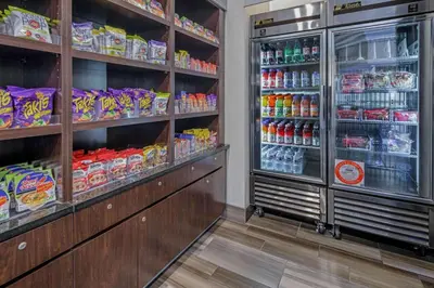 a store aisle with a refrigerator filled with food at La Quinta by Wyndham Anaheim in Anaheim