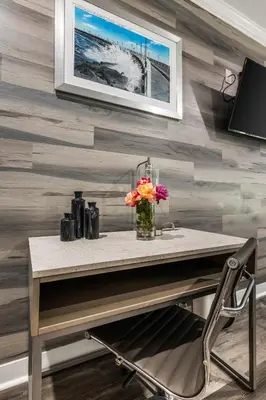 a table with a vase of flowers on a wall at Lumea by the Sea Long Beach Convention Center in Long Beach