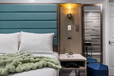 a bedroom with a bed with a blue headboard at Lumea by the Sea Long Beach Convention Center in Long Beach