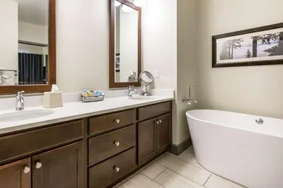 a bathroom with a tub and a sink and a mirror at Bluegreen Vacations Big Bear Village, an Ascend Collection Resort in Big Bear Lake