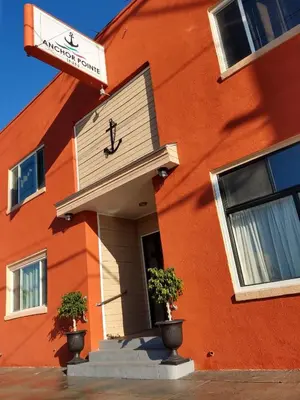 an orange building with two potted plants in front of it at Anchor Pointe Inn in Wilmington