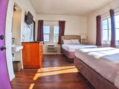 a hotel room with two beds and a dresser at Anchor Pointe Inn in Wilmington