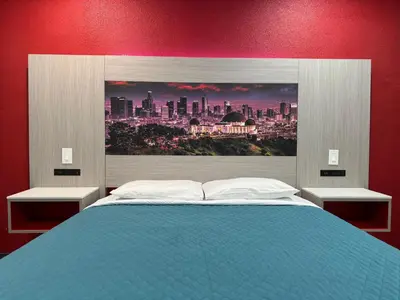 a bedroom with a blue bed with a picture of a city at Lincoln Motel - Los Angeles, Hollywood Area in Pasadena