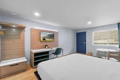 a bedroom with a bed and a desk and a chair at Travelodge by Wyndham Fairplex Pomona in Pomona