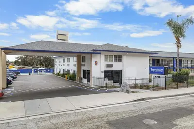 a building with a parking lot in front of it at Travelodge by Wyndham Fairplex Pomona in Pomona