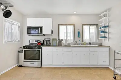 a kitchen with white cabinets and a stove at Long Beach House in Long Beach