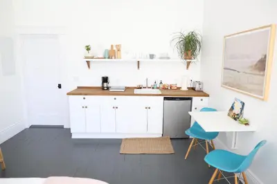 a kitchen with a sink and blue chairs at The Burlington in Los Angeles