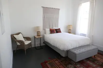a bedroom with a large white bed and a chair at The Burlington in Los Angeles
