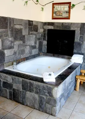 a bath tub in a room with a stone wall at Fireside Lodge in Big Bear Lake