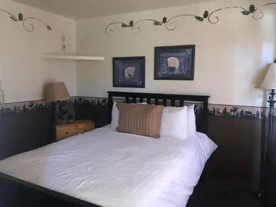 a bedroom with a bed with white sheets and pillows at Fireside Lodge in Big Bear Lake