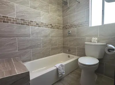 a bathroom with a white tub and a toilet and a sink at Budget Inn On Historic Route 66, Barstow in Barstow