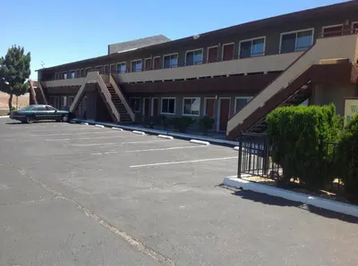 a parking lot in front of a building with a staircase at Budget Inn On Historic Route 66, Barstow in Barstow