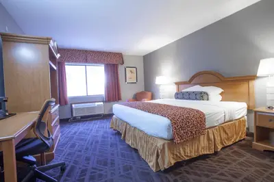 a hotel room with a bed and a desk at Ramada by Wyndham Barstow in Barstow