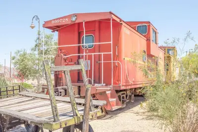 a red train car sitting next to a wooden platform at Ramada by Wyndham Barstow in Barstow