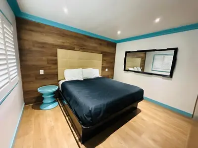 a bedroom with a bed and a mirror on the wall at Casa Blanca Inn - Whittier, Los Angeles in Whittier
