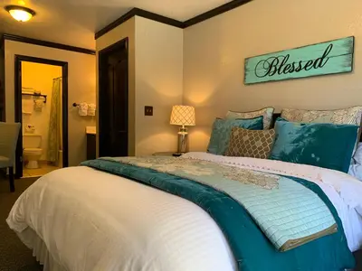 a bedroom with a large bed with a sign on the wall at The North Shore Inn in Crestline