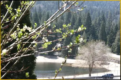 a car is parked on a road near a lake at The North Shore Inn in Crestline