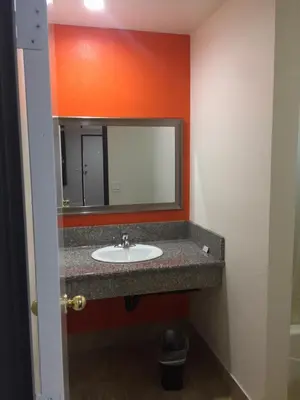 a bathroom with a sink and a mirror at Welcome Inn & Suites Anaheim in Anaheim