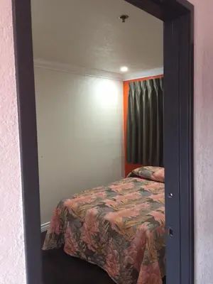 a bedroom with a bed and a mirror at Welcome Inn & Suites Anaheim in Anaheim