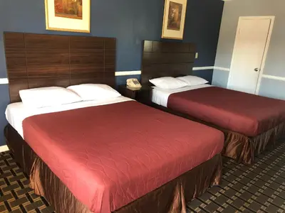 a hotel room with two beds with red covers at Whittier Travel Inn in Whittier