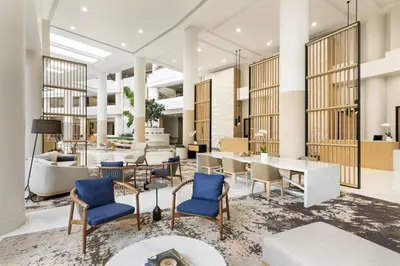 a lobby with blue chairs and a table at The Westin Long Beach in Long Beach