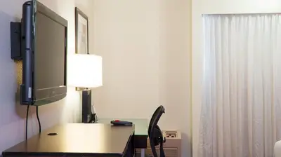 a room with a desk with a tv and a monitor at Motel 6 - Anaheim Hills, CA in Anaheim