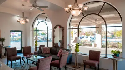 a living room with arched windows and a couch at Motel 6 - Anaheim Hills, CA in Anaheim