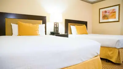 a hotel room with two beds with yellow pillows at Motel 6 - Anaheim Hills, CA in Anaheim