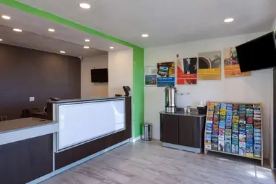 a waiting area at a fast food restaurant with a large white screen at Studio 6-Barstow, CA in Barstow