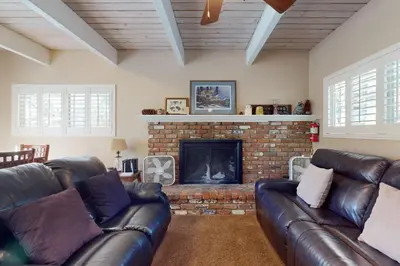 a living room with leather couches and a fireplace at Dancing Bear Chalet in Lake Arrowhead