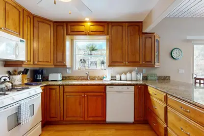 a kitchen with wooden cabinets and a white dishwasher at Dancing Bear Chalet in Lake Arrowhead