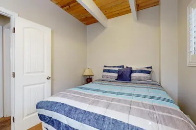 a bedroom with a bed with blue and white sheets at Dancing Bear Chalet in Lake Arrowhead