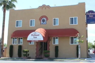 a restaurant with a sign in front of a building at Holland Inn and Suites in Taft