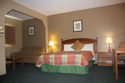 a hotel room with a bed and a couch at Holland Inn and Suites in Taft