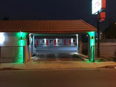 a gas station with green lights at night at Rocky Inn Motel in Lynwood