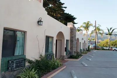 a row of buildings with palm trees and a street at Casa Del Sol in Carpinteria