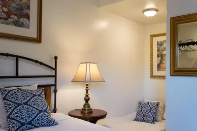 a bedroom with a bed and a lamp and a chair at Casa Del Sol in Carpinteria