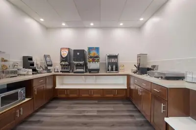 a large kitchen with wooden cabinets and appliances at SureStay Plus Hotel by Best Western Upland - Ontario North in Upland