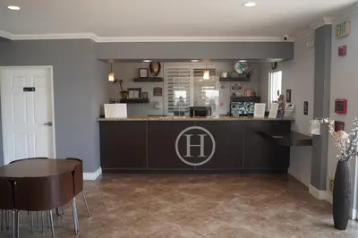 a restaurant with a counter and a table and chairs at Harbor Inn & Suites in Anaheim