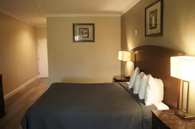 a hotel room with a bed and two lamps at Harbor Inn & Suites in Anaheim