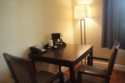 a room with a table with a telephone and chairs at Harbor Inn & Suites in Anaheim