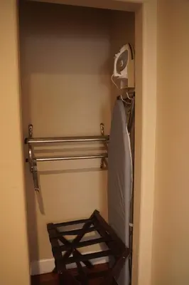 a room with a bed and a towel rack at Harbor Inn & Suites in Anaheim