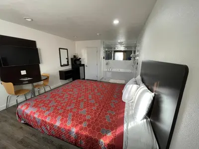 a bedroom with a bed and a desk and a television at Claremont Lodge in Claremont