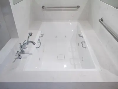 a white bath tub with faucets in a bathroom at Claremont Lodge in Claremont